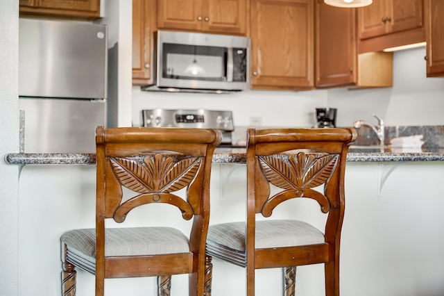 kitchen featuring stone counters, sink, and appliances with stainless steel finishes