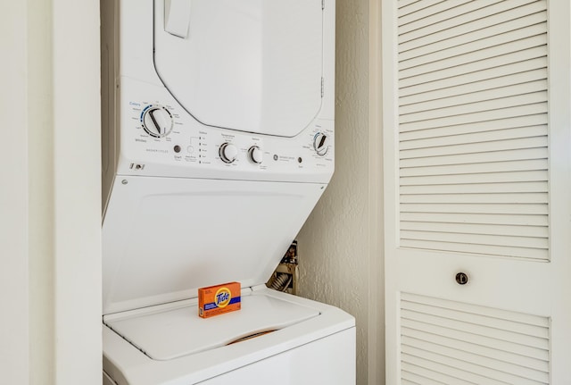 clothes washing area featuring stacked washer and clothes dryer