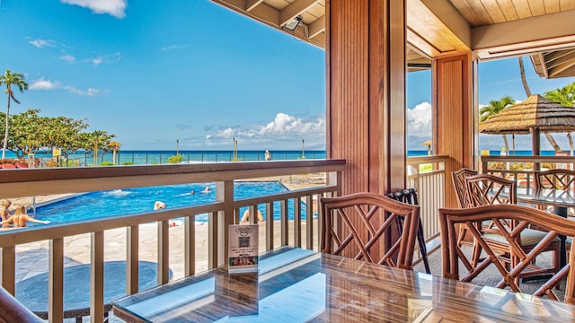 balcony featuring a water view and a beach view