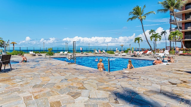 view of swimming pool with a patio area and a water view