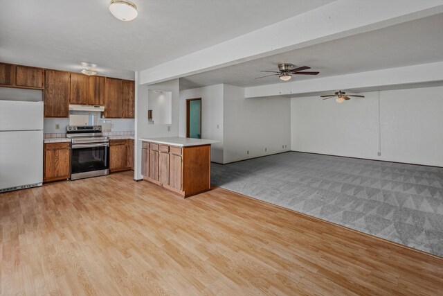 29 Hale Malia Pl, Lahaina, HI 96761 - kitchen featuring stainless steel electric range oven, freestanding refrigerator, under cabinet range hood, brown cabinets, and light countertops