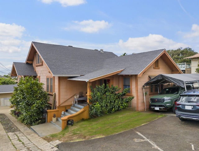 view of front facade with a carport and a shingled roof