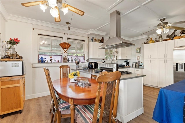 kitchen with light wood finished floors, ornamental molding, white cabinetry, stainless steel fridge, and island range hood