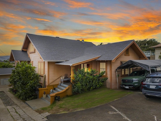 view of front facade featuring a detached carport and a shingled roof