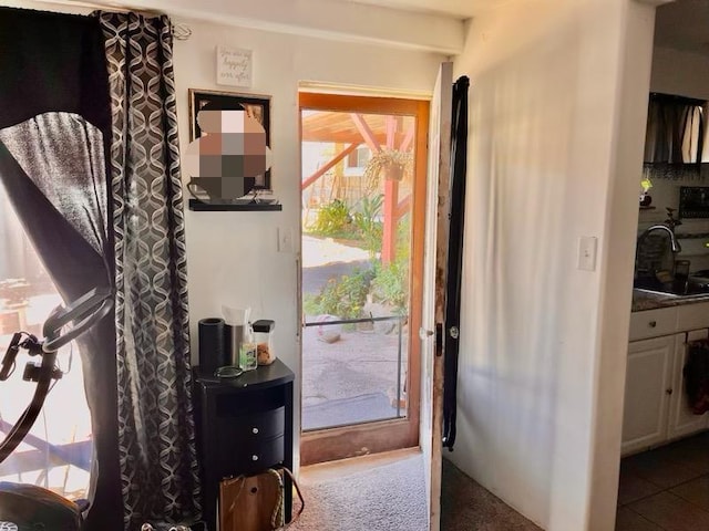 doorway to outside featuring a sink and tile patterned floors