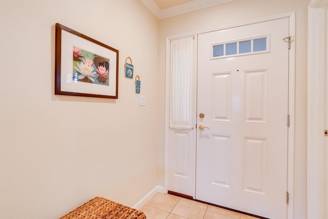foyer entrance featuring ornamental molding, baseboards, and light tile patterned floors