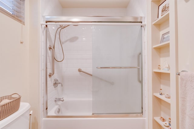 bathroom featuring shower / bath combination with glass door and toilet