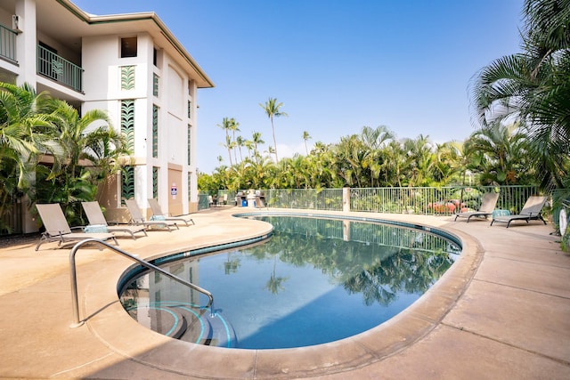 community pool featuring a patio area and fence