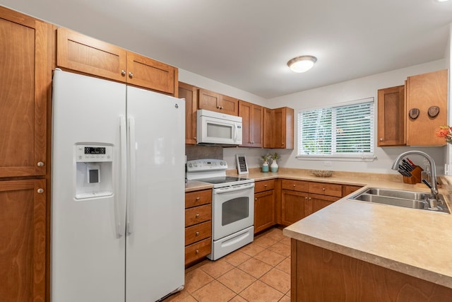 kitchen featuring white appliances, sink, and light tile patterned floors