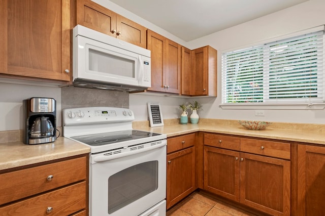 kitchen with white appliances and light tile patterned floors