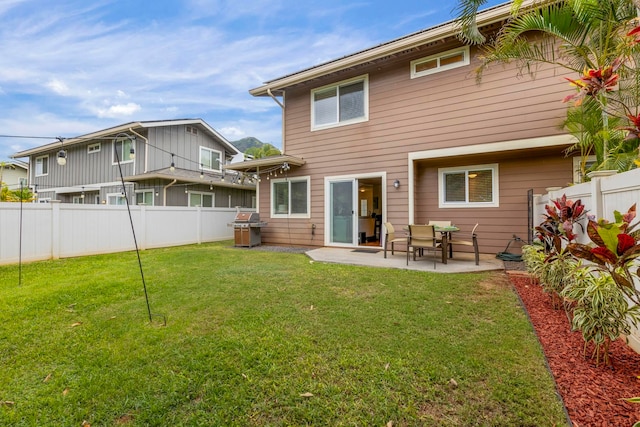 back of house with a yard and a patio