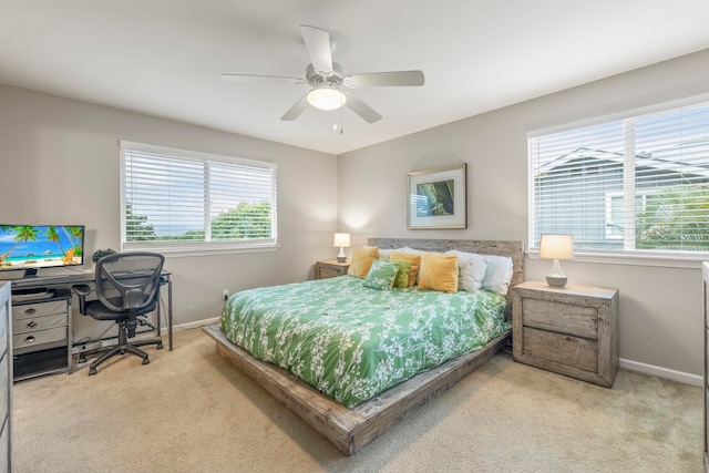 carpeted bedroom featuring multiple windows and ceiling fan