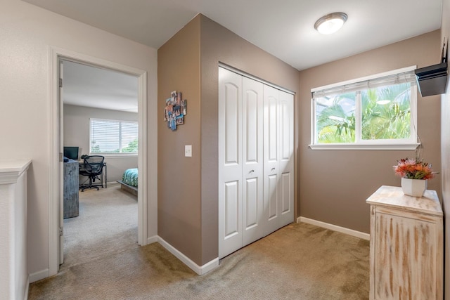 hall featuring light colored carpet