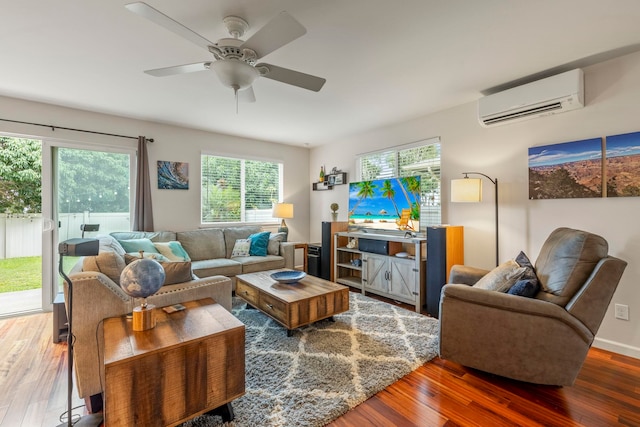 living room featuring ceiling fan, dark hardwood / wood-style flooring, and a wall unit AC