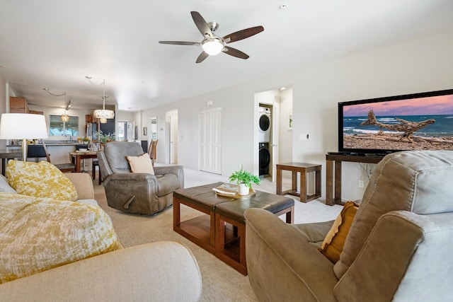 living room with ceiling fan, stacked washer and clothes dryer, and light colored carpet