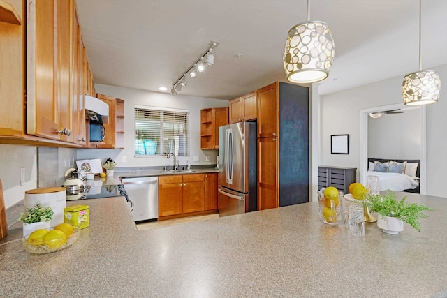 kitchen featuring sink, decorative light fixtures, stainless steel appliances, and kitchen peninsula