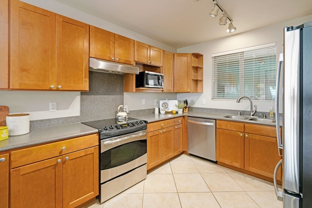 kitchen featuring light tile patterned flooring, track lighting, stainless steel appliances, and sink