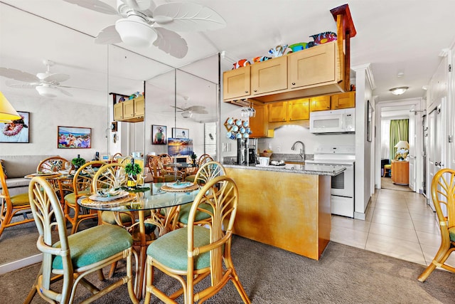 kitchen featuring sink, light stone counters, kitchen peninsula, white appliances, and light tile patterned floors