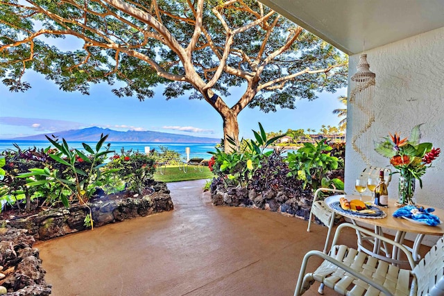 view of patio featuring a water and mountain view