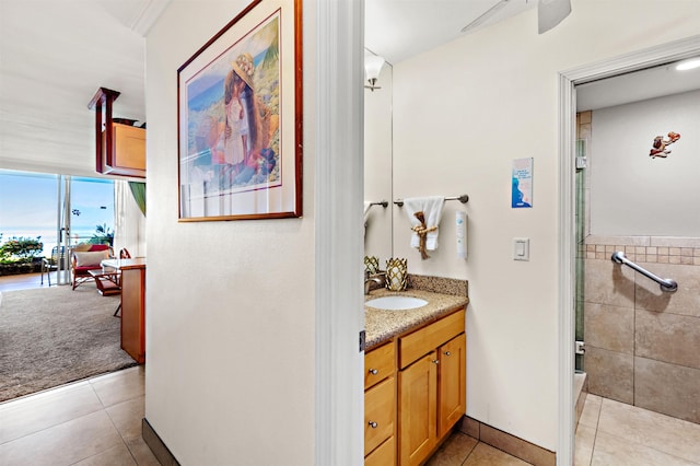 bathroom with tile patterned flooring, vanity, ceiling fan, and tile walls