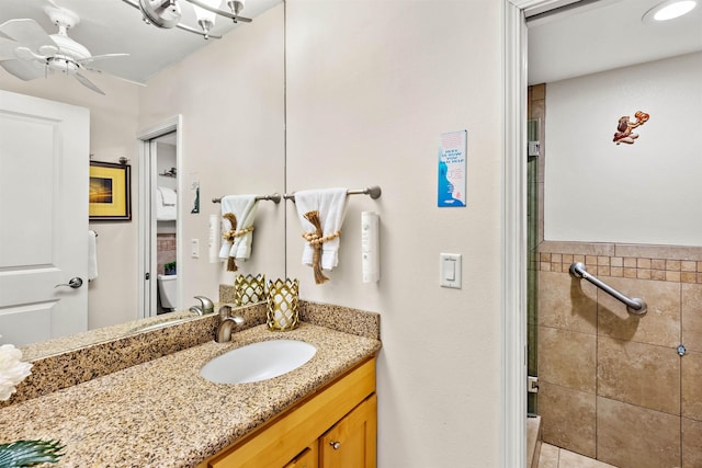 bathroom featuring vanity, ceiling fan, toilet, and tile walls