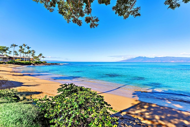 water view with a mountain view and a view of the beach