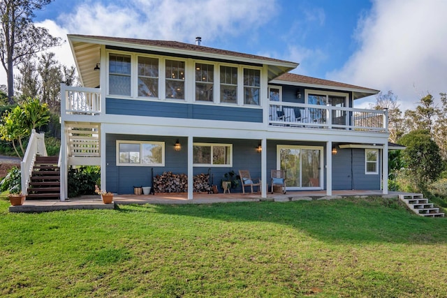 rear view of house featuring a balcony, a yard, and a patio