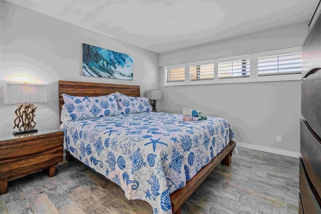 bedroom with baseboards and wood finished floors