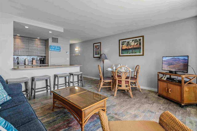 living area with light wood-style floors, baseboards, visible vents, and recessed lighting