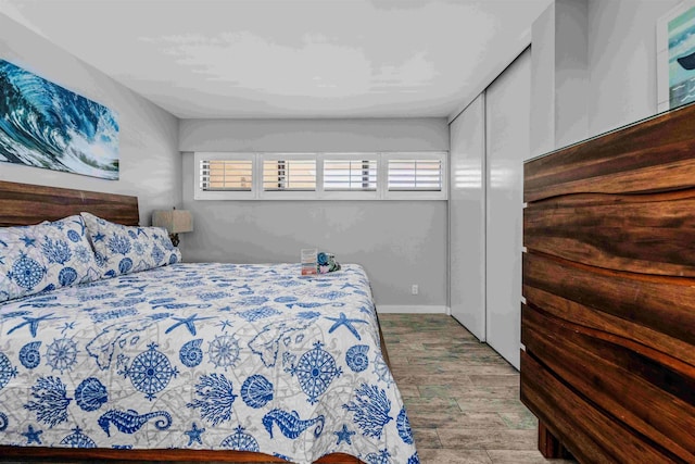 bedroom featuring multiple windows, a closet, and light hardwood / wood-style floors