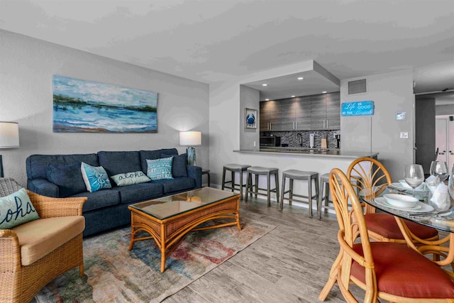 living room featuring wood finished floors, visible vents, and recessed lighting