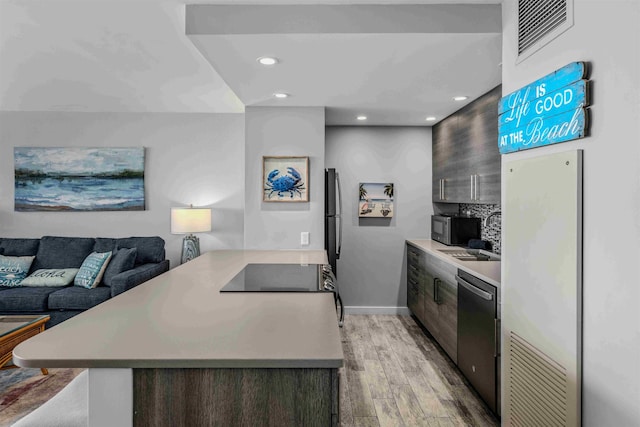 kitchen featuring dishwasher, light wood-style flooring, modern cabinets, a peninsula, and light countertops