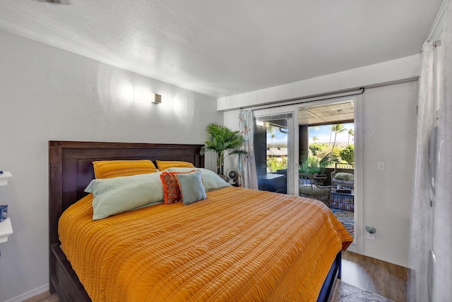 bedroom featuring wood-type flooring and access to outside