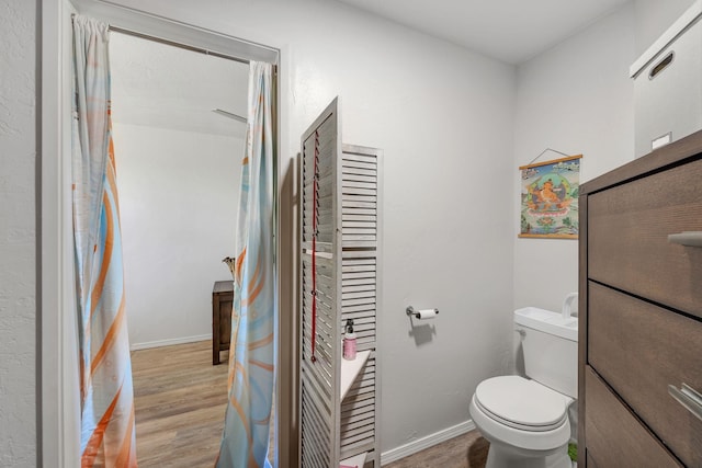 bathroom featuring hardwood / wood-style flooring and toilet