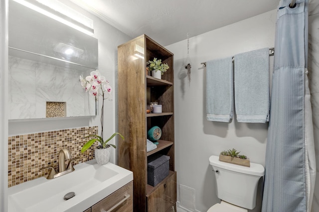 bathroom featuring vanity, toilet, and backsplash