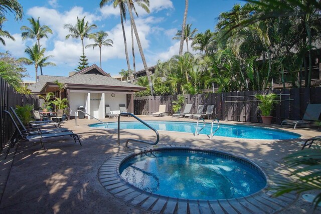 view of swimming pool featuring an in ground hot tub and a patio area