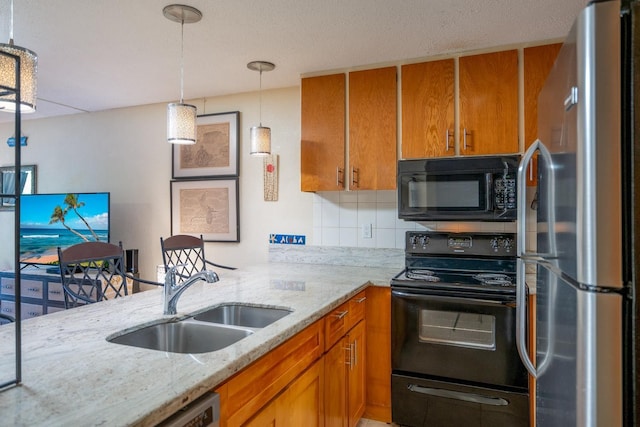 kitchen featuring sink, decorative backsplash, hanging light fixtures, black appliances, and light stone countertops