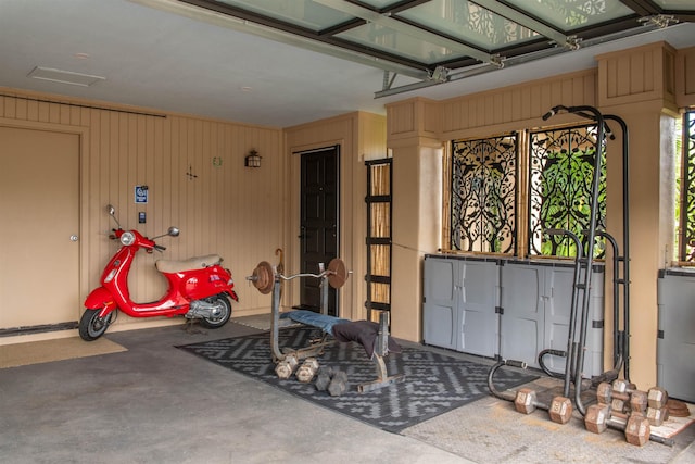 exercise room with wood walls and electric water heater