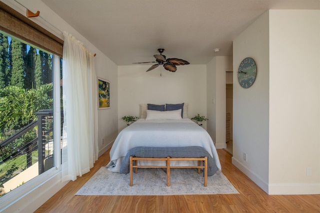 bedroom featuring ceiling fan, light hardwood / wood-style floors, and multiple windows