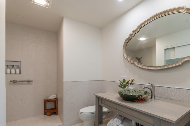 bathroom with sink, tile walls, and toilet