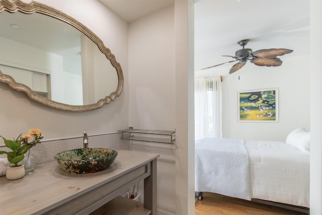 bathroom with hardwood / wood-style floors, ceiling fan, and vanity