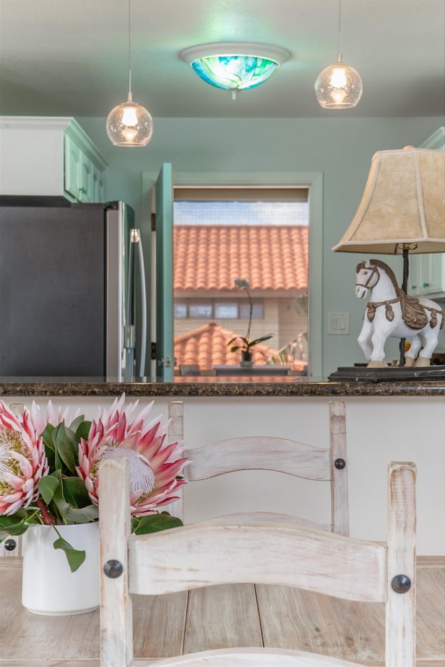 interior details featuring hanging light fixtures and stainless steel refrigerator