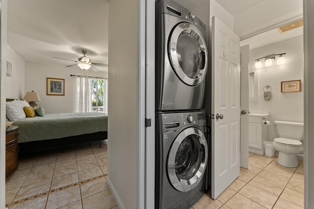 480 Kenolio Rd Unit 21-101, Kihei, HI 96753 - laundry area featuring stacked washer / dryer, light tile patterned flooring, and a ceiling fan