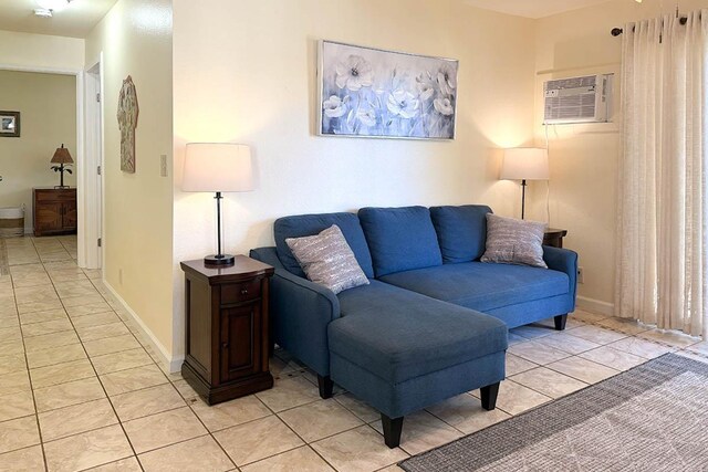 480 Kenolio Rd Unit 21-101, Kihei, HI 96753 - living room featuring light tile patterned flooring, a wall unit AC, and baseboards