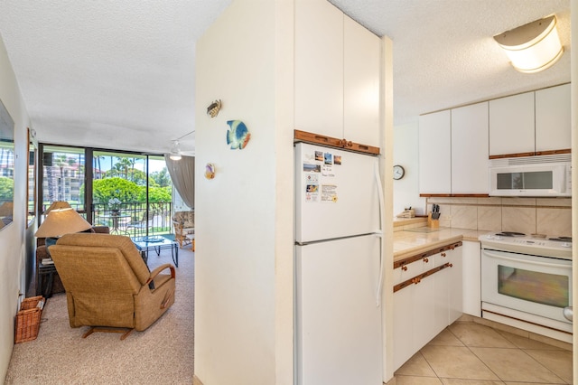 2695 S Kihei Rd Unit 1204, Kihei, HI 96753 - kitchen with white appliances, a textured ceiling, white cabinets, floor to ceiling windows, and decorative backsplash