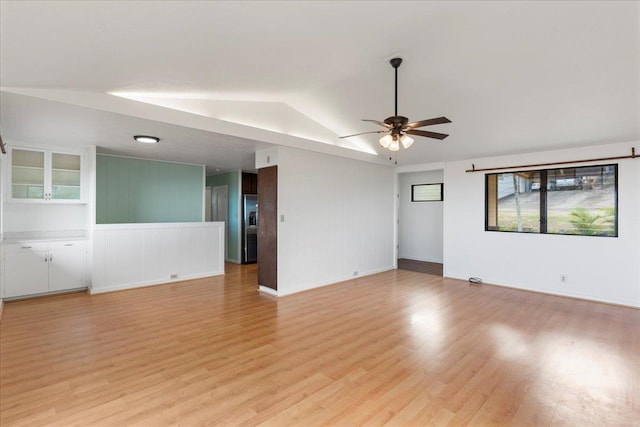 unfurnished room featuring ceiling fan, vaulted ceiling, and light wood-type flooring