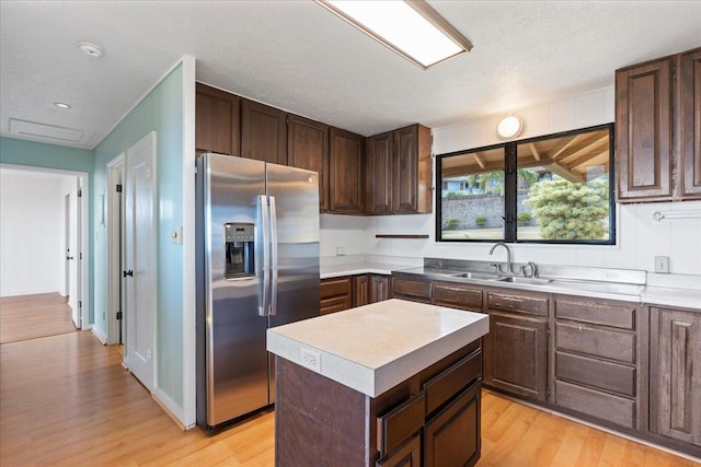 263 S Alu Rd, Wailuku, HI 96793 - kitchen with stainless steel fridge, a sink, light wood-style floors, dark brown cabinetry, and light countertops