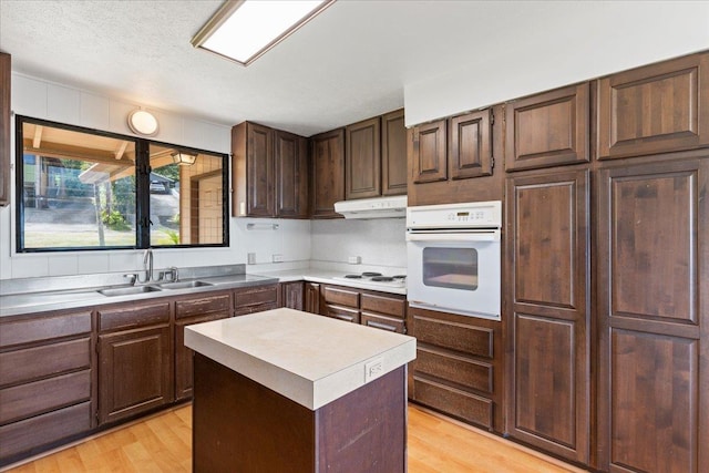 263 S Alu Rd, Wailuku, HI 96793 - kitchen featuring white appliances, under cabinet range hood, a sink, light wood finished floors, and light countertops