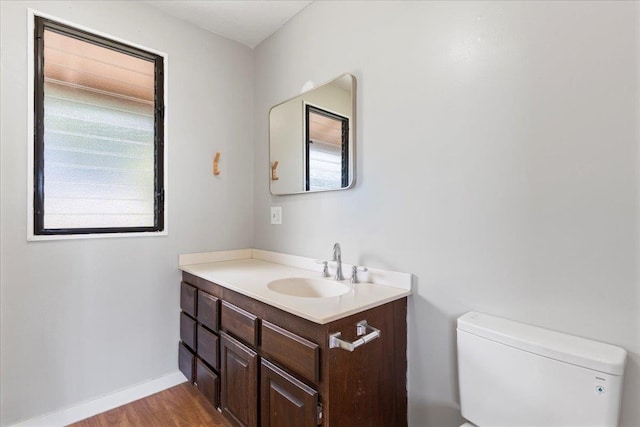 bathroom featuring vanity, toilet, wood-type flooring, and plenty of natural light