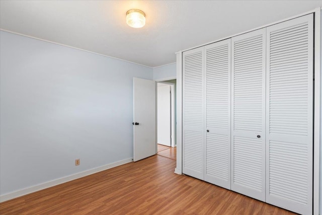 unfurnished bedroom featuring wood-type flooring and a closet